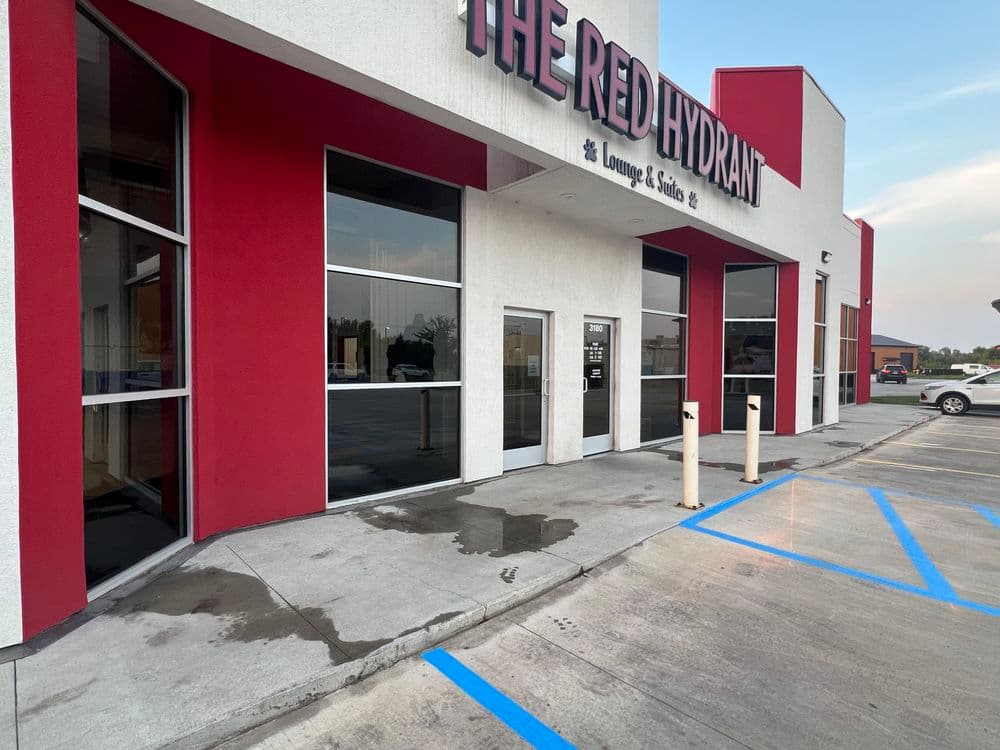 Exterior view of The Red Hydrant lounge, showcasing modern architecture and signage.